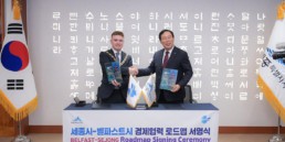 Belfast Lord Mayor and Sejong Mayor shaking hands and holding copies of the Innovation Twins Roadmap.